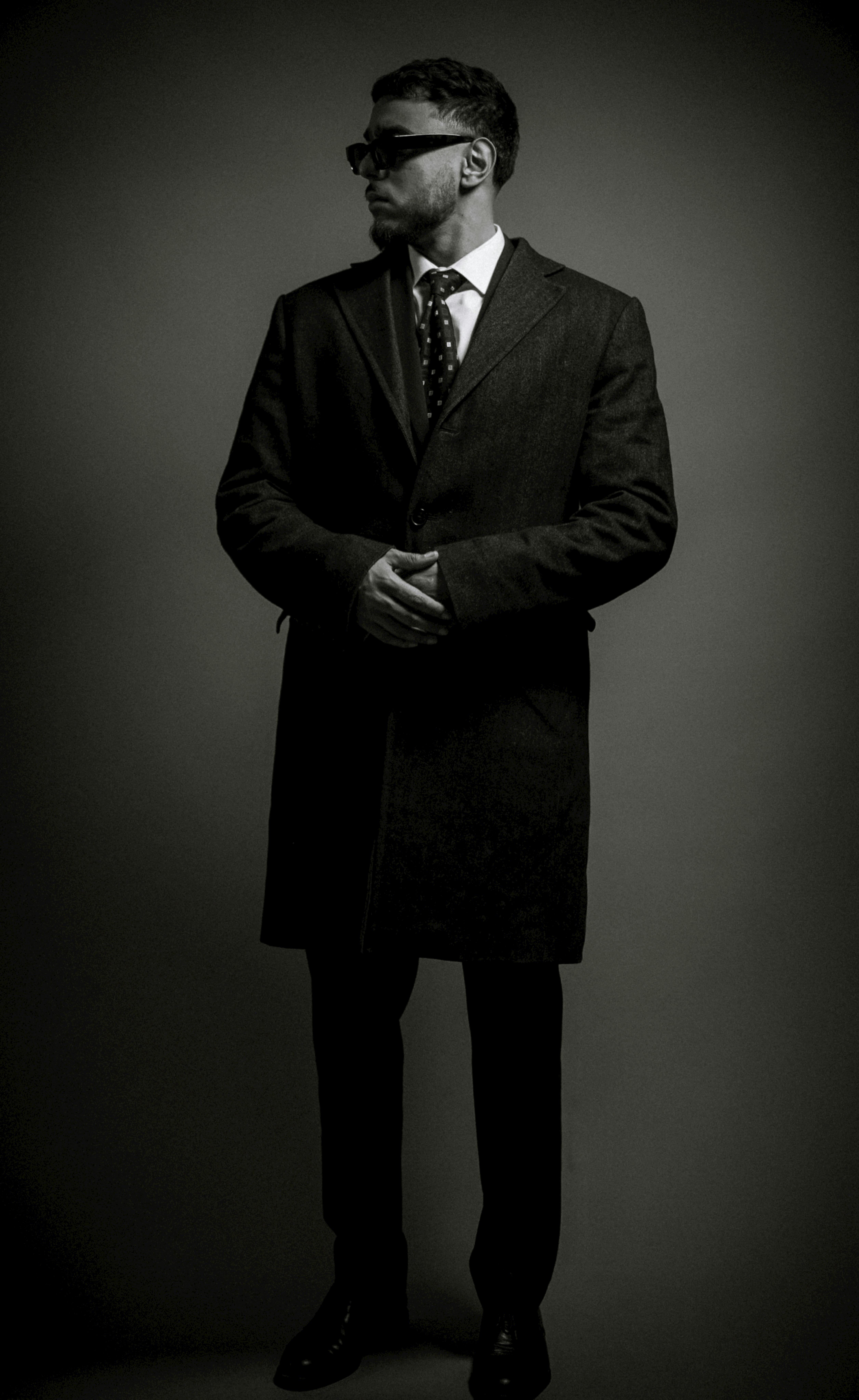 Formal portrait with dark sunglasses suggesting authority